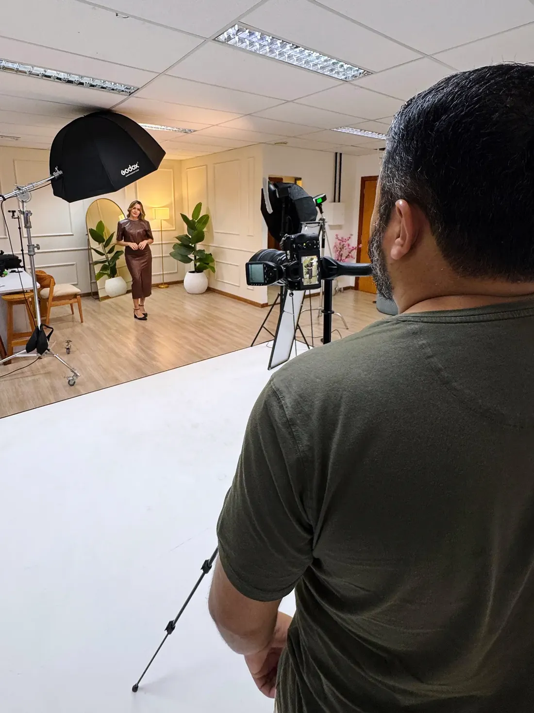 Bastidor de estúdio: iluminação montada e fotógrafo conduzindo a sessão