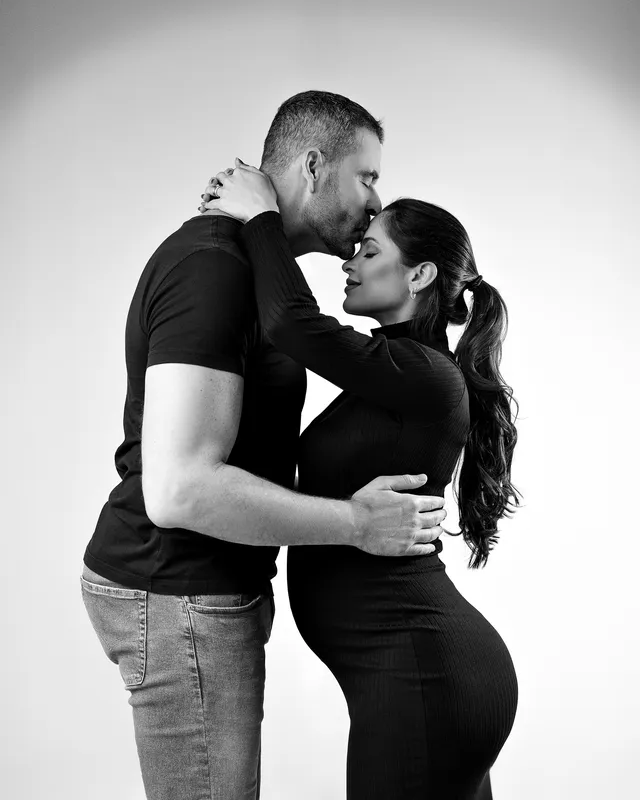 Casal em preto e branco no estúdio, testa colada na testa
